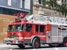 Detailed view of a red fire truck in Montreal with building background.