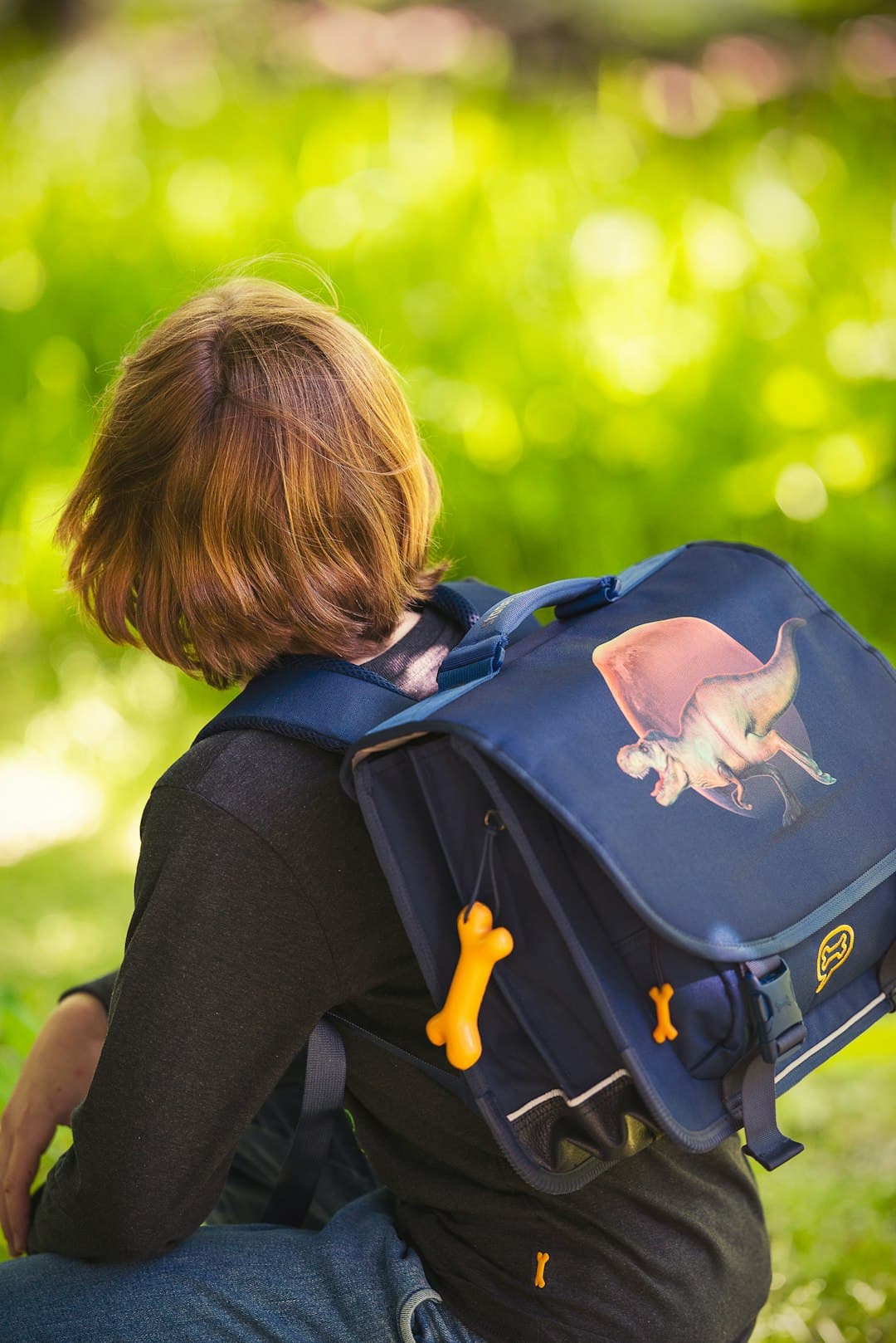 A child sits with a backpack.